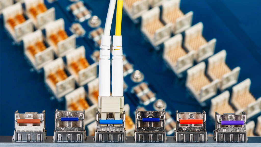 Close-up of fiber optic connectors and GBIC modules in a data center switch.