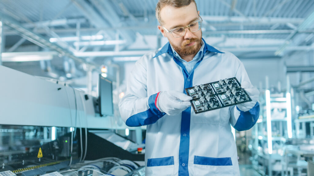 echnician inspecting a PCB assembled via SMT on a high-speed production line.