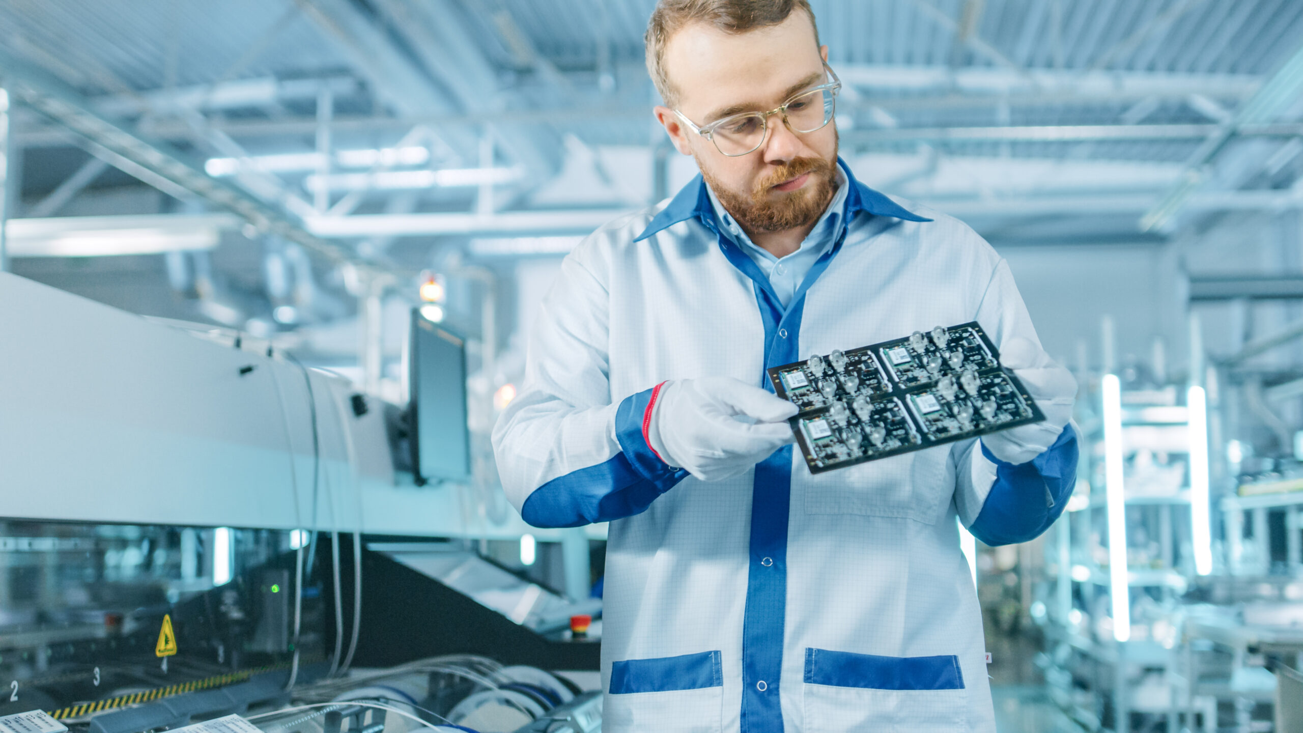 echnician inspecting a PCB assembled via SMT on a high-speed production line.